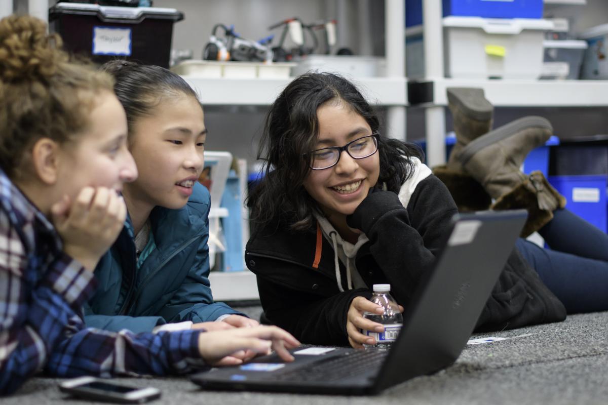 Girls use a laptop at a Girls Who Code club.